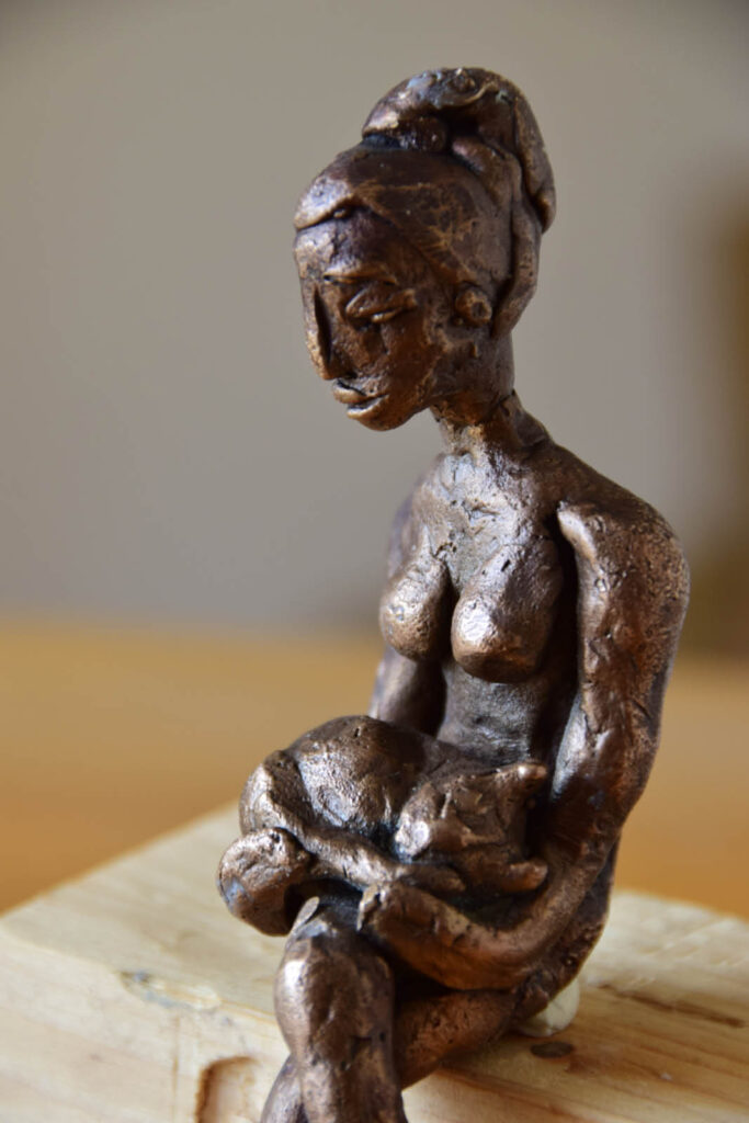 Skulpturen. Bronzeskulptur einer Frau mit einer Katze auf dem Schoss.