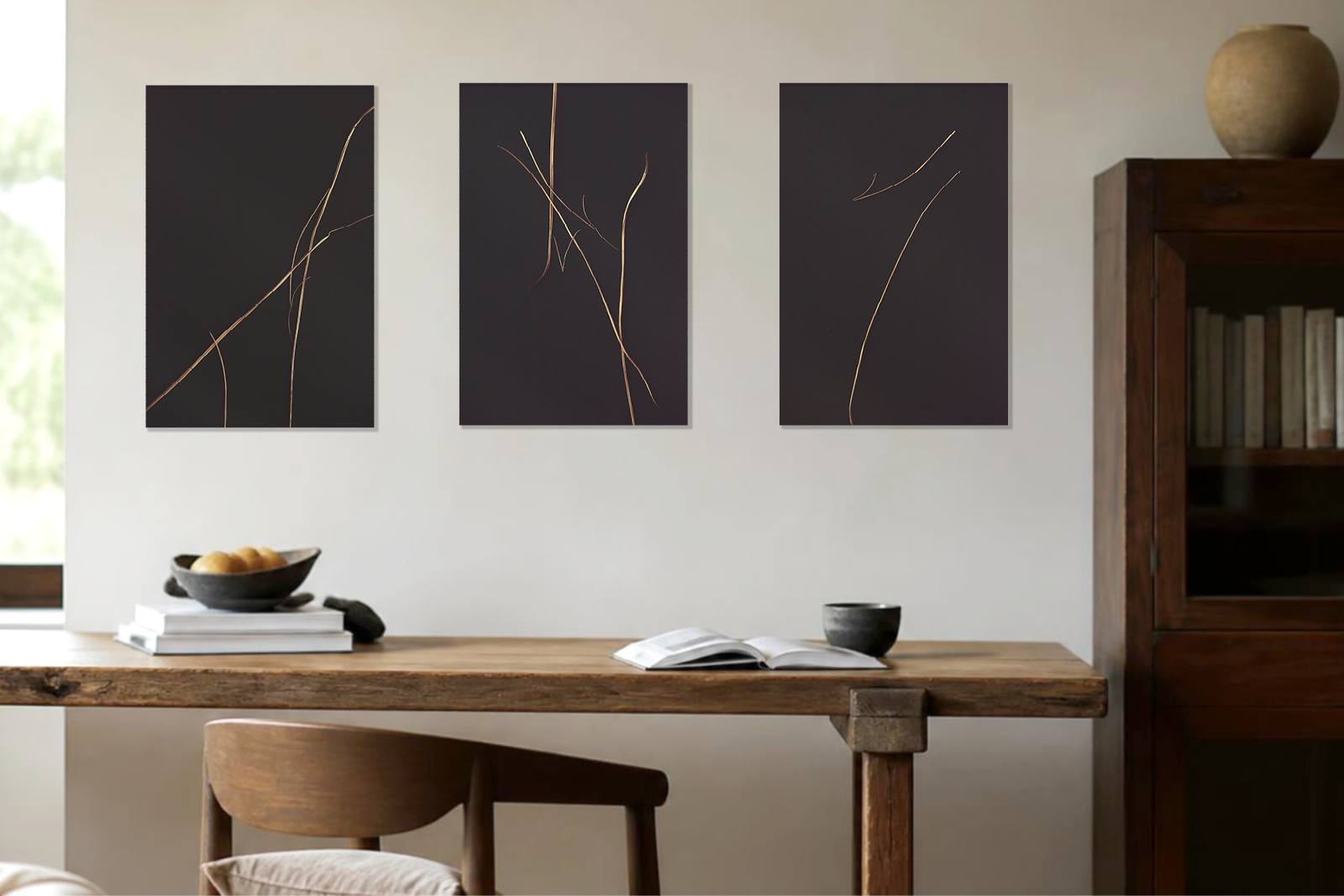 Drei Fine-Art-Prints aus der Wabi-Sabi-Serie von Kathleen Sandböck hängen über einem Holztisch in einem hellen Interieur.