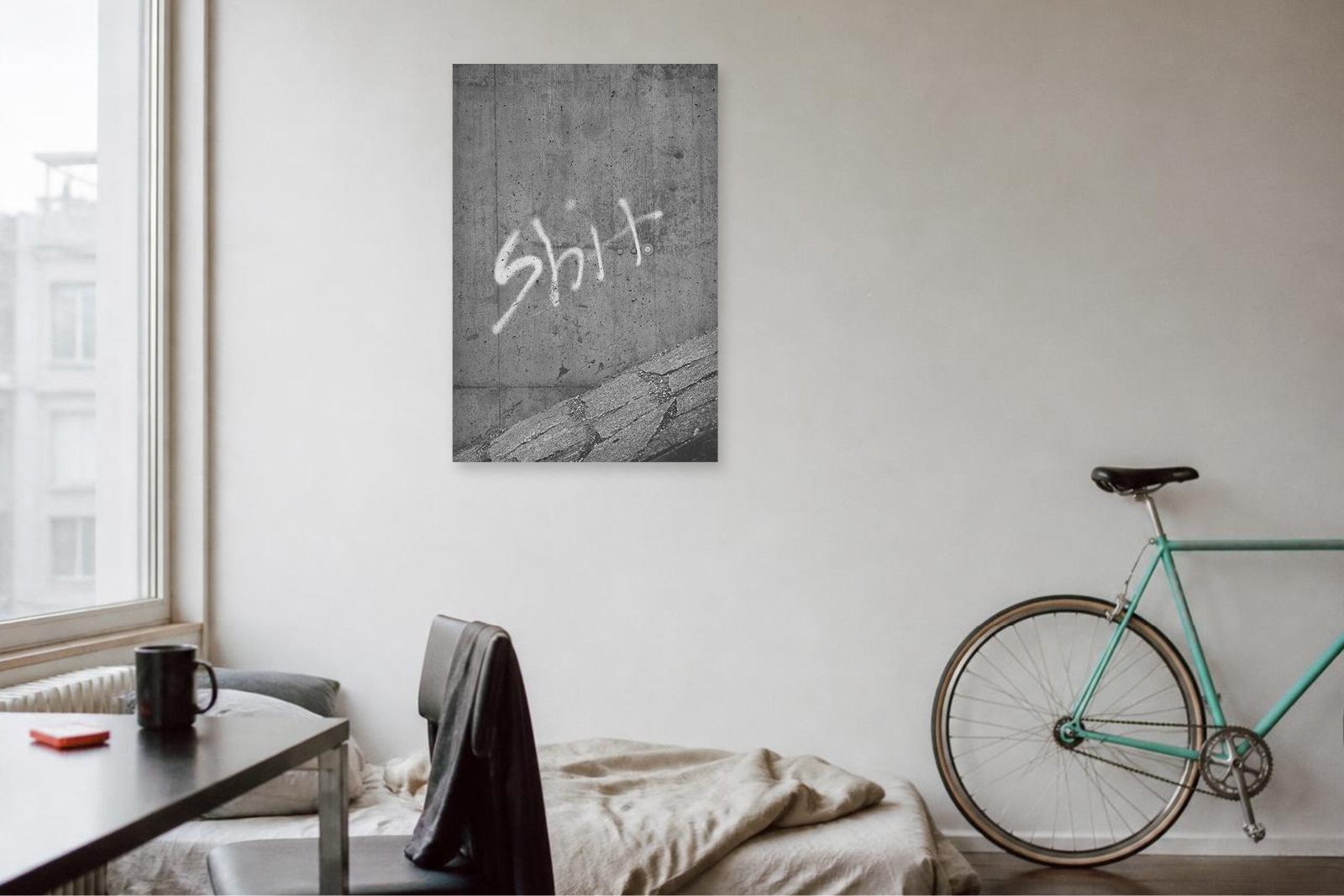 Fine-Art-Print einer verwitterten Betonwand mit Graffiti an einer hellen Wand in einem minimalistischen Wohnraum.