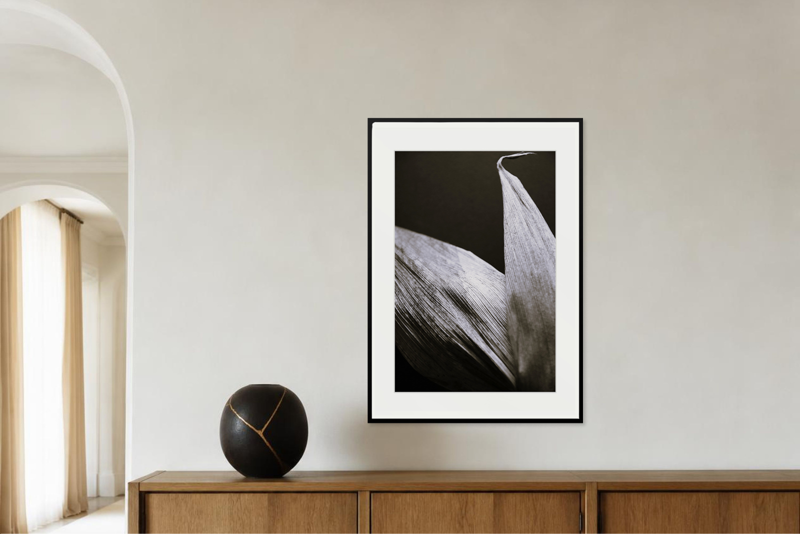 Großformatiger Fine-Art-Print einer fotografischen Studie getrockneter Maisblätter über einem Holzsideboard.